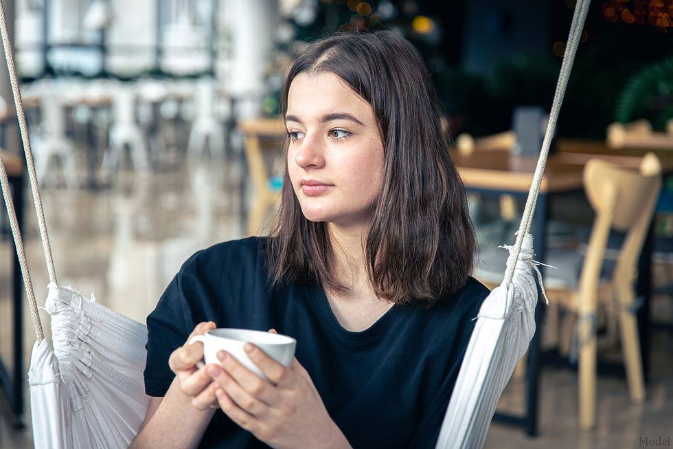 A woman with a blank expression holding a cup
