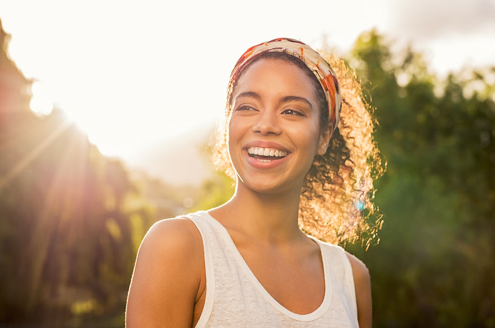 Woman smiling with the sun shining behind her