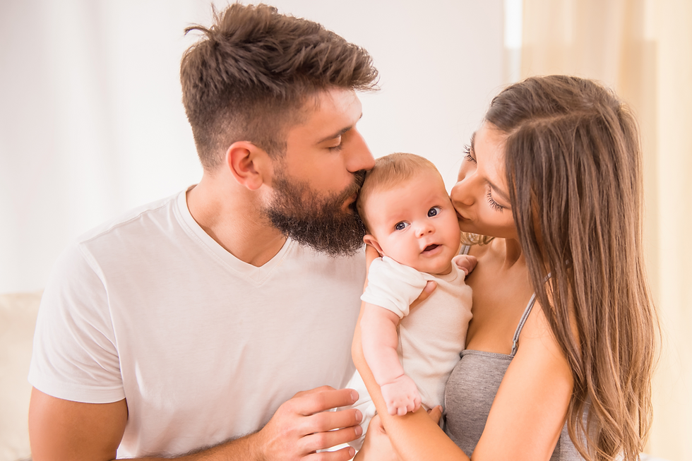 Parents kissing baby on the head